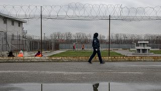 A prison guard inspects inmates at the detention centre of Lipljan.