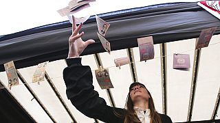 Una manifestante arroja billetes fuera de circulación en una protesta en Milán, Italia, 16/12/2021