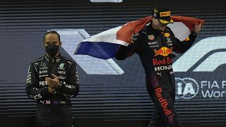 Lewis Hamilton (L) applauds as Red Bull driver Max Verstappen celebrates his victory in Abu Dhabi.