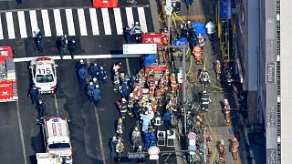 Policemen and firefighters gather near a building where a fire broke out in Osaka, western Japan, Dec. 17, 2021.