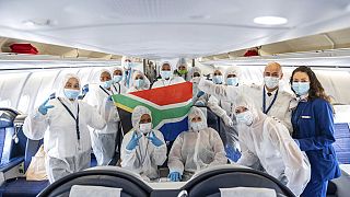 Die Besatzung eines "South African Airlines" Fluges posiert nach ihrem vorerst letzten Flug aus Kapstadt in Schutzkleidung in Frankfurt, 24.04.2020.