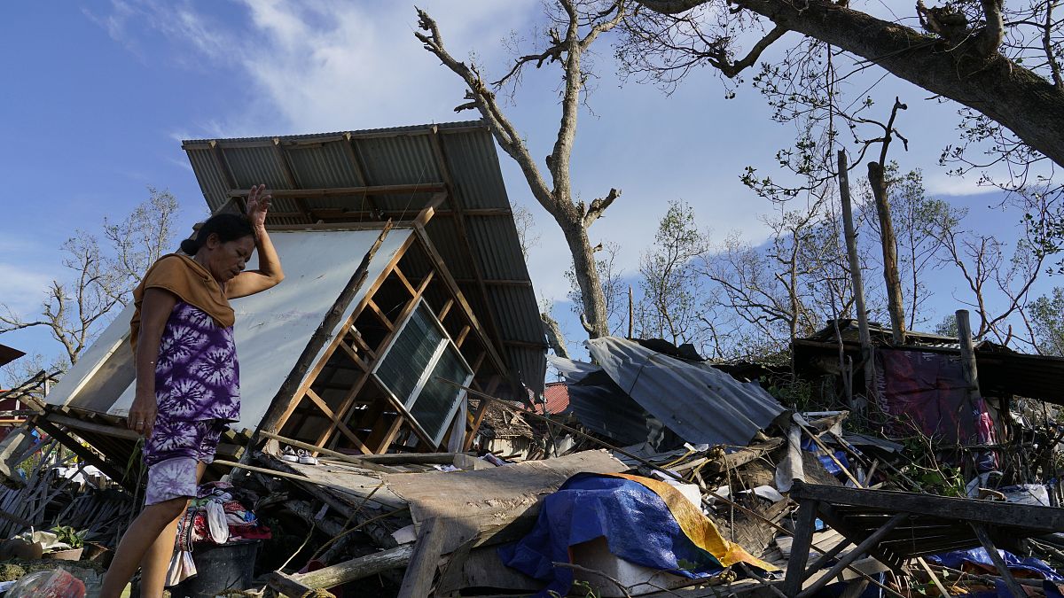 Una residente rescata partes de su casa dañada por el tifón Rai en Talisay, provincia de Cebú, en el centro de Filipinas, el 18 de diciembre de 2021. 