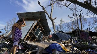 Una residente rescata partes de su casa dañada por el tifón Rai en Talisay, provincia de Cebú, en el centro de Filipinas, el 18 de diciembre de 2021.