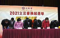 Miembros de la Federación de Sindicatos de Hong Kong pro-Pekín, se inclinan ante sus partidarios, 20/12/2021, Hong Kong