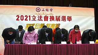 Miembros de la Federación de Sindicatos de Hong Kong pro-Pekín, se inclinan ante sus partidarios, 20/12/2021, Hong Kong
