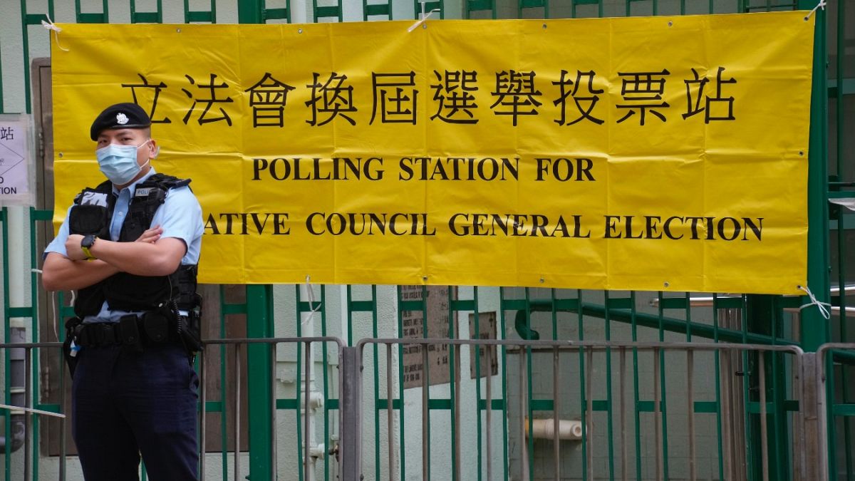 A police officer stands guard outside a polling station in Hong Kong Sunday, Dec. 19, 2021. 