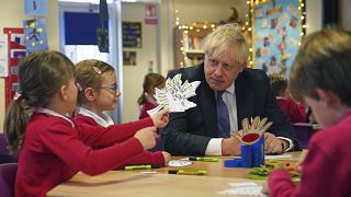 Britain's Prime Minister Boris Johnson interacts with school children, during a visit to Westbury-On-Trym Church of England Academy in Bristol, England, Oct. 15, 2021.