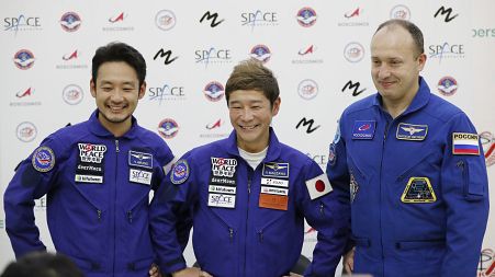 Roscosmos cosmonaut Alexander Misurkin (R), Japanese billionaire Yusaku Maezawa (C), and assistant Yozo Hirano at a news conference in Star City outside Moscow, Oct. 14, 2021.