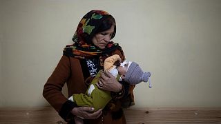 Simien Arian holds her malnourished nine-month-old grandchild Maaz in the Indira Gandhi hospital in Kabul, Afghanistan, Monday, Nov. 8, 2021.