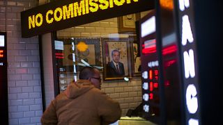 A portrait of Turkey's President Recep Tayyip Erdogan hangs in a money exchange shop in Istanbul, Turkey, Monday, Dec. 20, 2021.