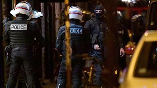 Policemen and members of the French Research and Intervention Brigade (BRI) unit stand outside a hardware shop, where two women are held hostage in Paris, Dec. 20, 2021.