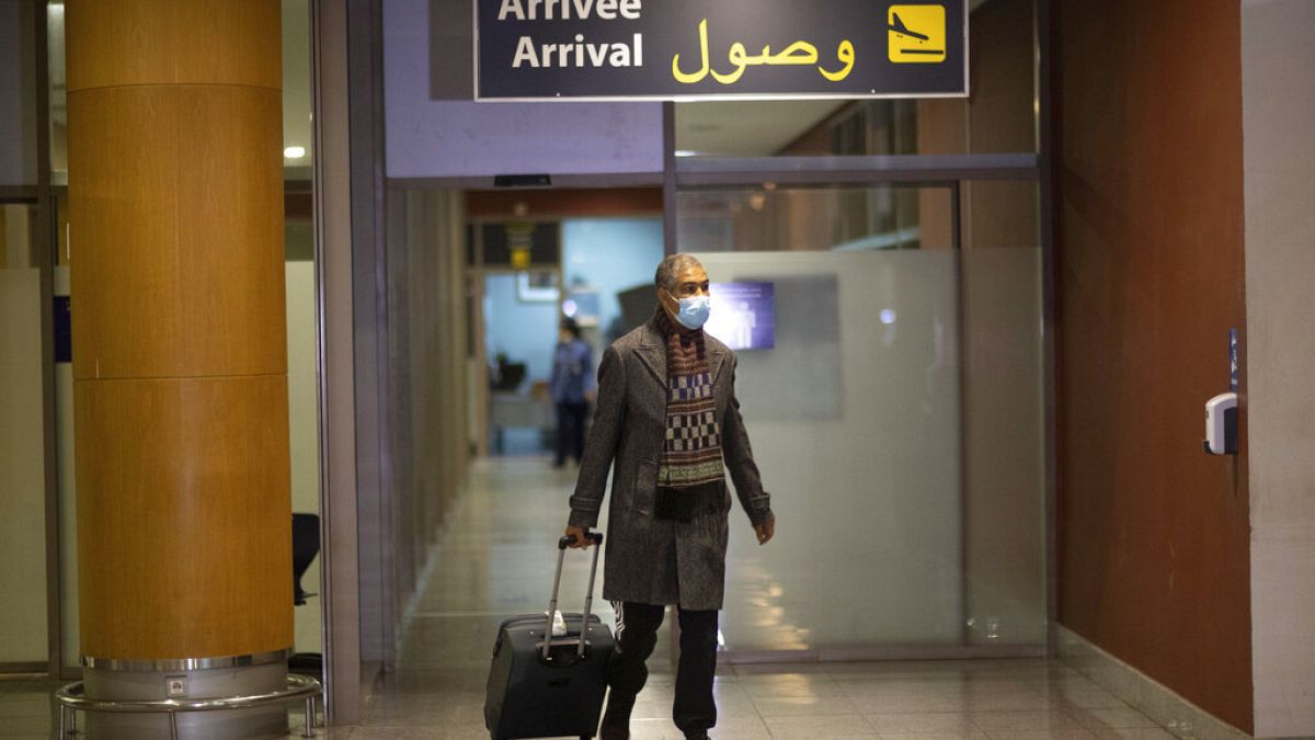 مسافر على متن الرحلة الأخيرة إلى المغرب قبل تعليق الرحلات، يصل إلى صالة بمطار الرباط، المغرب، الإثنين 29 نوفمبر 2021.