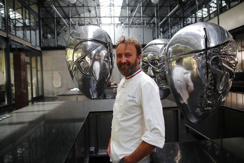 Chocolatier Patrick Roger stands next his sculptures inspired by Pope Francis in his factory-studio in Sceaux, Paris.