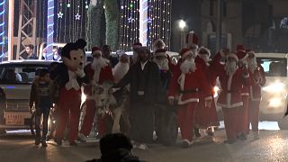 Santa Claus roaming the streets of the Iraqi town of al-Hamdaniya, accompanied by donkey cart.