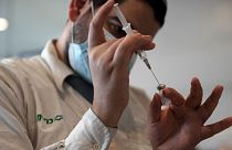 A medical worker prepares a vial of the Pfizer coronavirus vaccine at Clalit Health Service's center in the Cinema City complex in Jerusalem, September 2021.