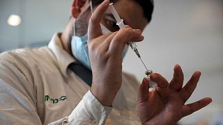 A medical worker prepares a vial of the Pfizer coronavirus vaccine at Clalit Health Service's center in the Cinema City complex in Jerusalem, September 2021.