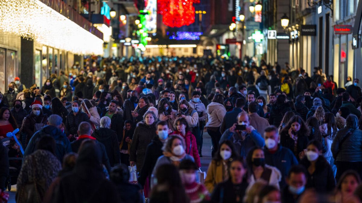 Personas con mascarillas para frenar la propagación del coronavirus caminan en el centro de Madrid, España, el martes 21 de diciembre de 2021.