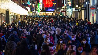 Personas con mascarillas para frenar la propagación del coronavirus caminan en el centro de Madrid, España, el martes 21 de diciembre de 2021.