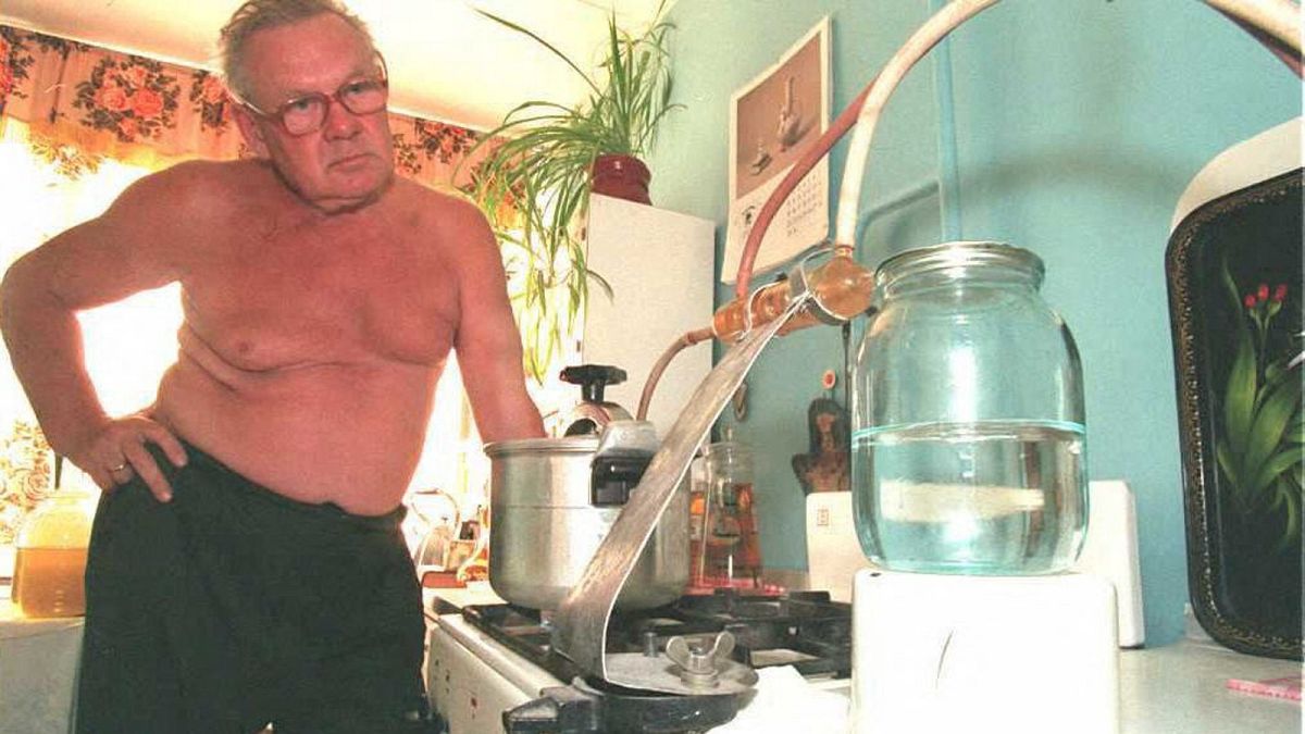 Seventy-year old Yevgueny Stepanovich checks the preparation of the 70 degrees "Zamagonka" or self-made alcohol also called "moonshine" in his house in Moscow, May 1995.