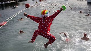 Persona vestida de payaso salta al Mediterráneo en Barcelona mientras participa en la Copa Nadal, una tradicional competición de natación que se celebra cada 25 de diciembre.