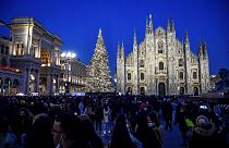 Una multitud fotografía el Doumo de Milán durante el encendido de luces