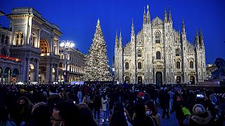 Una multitud fotografía el Doumo de Milán durante el encendido de luces