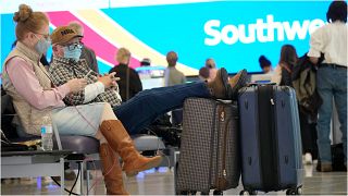 مسافرون ينتظرون في قاعة المغادرة بمطار دنفر بولاية كولورادو بالولايات المتحدة بعد أن تمّ إلغاء رحلتهم على خلفية انتشار متحوّرة "اوميكرون"، 24 ديسمبر 2021