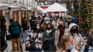 متسوقون يسيرون في سوق الـ"كريسماس" بحديقة تويليري في العاصمة الفرنسية، باريس، واضعين على وجوههم الكمامات للوقاية من الإصابة بـ"كوفيد-19"، 20 ديسمبر  2021
