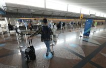 مسافر  ينتظر وحيداً في صالة مطار دنفر الدولي 24 ديسمبر 2021  بعد أن ألغت شركات الطيران الكبرى مئات الرحلات الجوية وسط نقص في الموظفين مرتبط إلى حد بعيد بانتشار "أوميكرون"