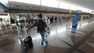مسافر  ينتظر وحيداً في صالة مطار دنفر الدولي 24 ديسمبر 2021  بعد أن ألغت شركات الطيران الكبرى مئات الرحلات الجوية وسط نقص في الموظفين مرتبط إلى حد بعيد بانتشار "أوميكرون"