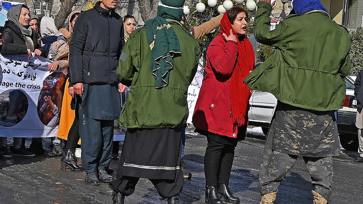 متظاهرة أفغانية تتحدث مع أحد عناصر طالبان في العاصمة كابل 16/12/2021