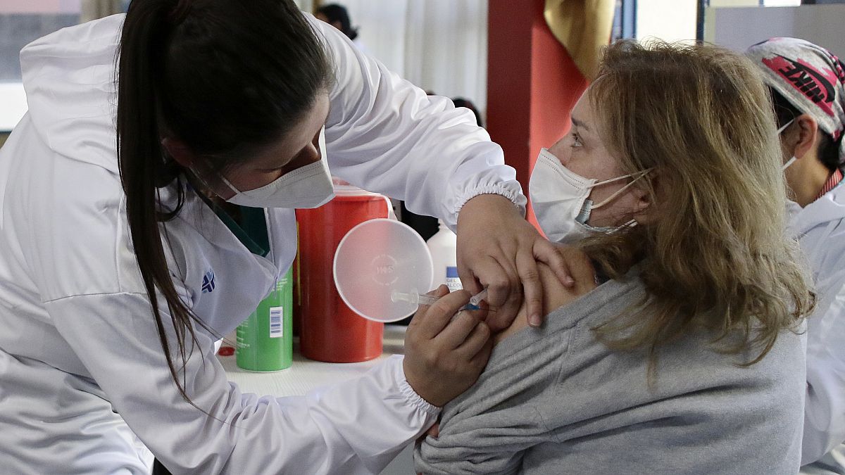 Une femme se fait vacciner à Quito en Equateur, premier pays à mettre en œuvre la vaccination obligatoire 