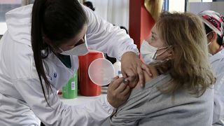Une femme se fait vacciner à Quito en Equateur, premier pays à mettre en œuvre la vaccination obligatoire