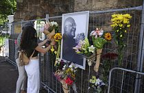 Des passants rendent hommage à Desmond Tutu, à l'extérieur de la Cathédrale Saint-Georges du Cap, Afrique du sud, le 26 décembre 2021