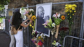 Des passants rendent hommage à Desmond Tutu, à l'extérieur de la Cathédrale Saint-Georges du Cap, Afrique du sud, le 26 décembre 2021