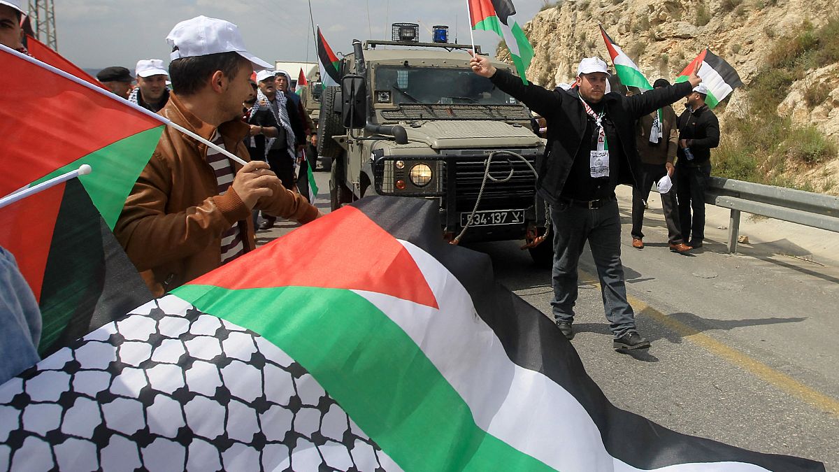 متظاهرون فلسطينيون يعترضون سيارة جيب عسكرية لقوات الأمن الإسرائيلية خلال مظاهرة لإحياء يوم الأرض، في قرية برقة بالضفة الغربية، غربي نابلس، في 30 مارس 2016