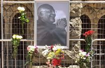 أزهار بجوار صورة لأيقونة جنوب إفريقيا المناهضة للفصل العنصري ديزموند توتو خارج كاتدرائية سانت جورج، في كيب تاون، في 26 ديسمبر 2021