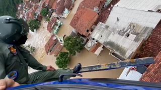 Helicopter lowering a basket to rescue stranded residents