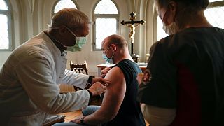 A doctor vaccinates a man against coronavirus inside the St. Petri church in the center of Chemnitz, Germany, Dec. 12, 2021.