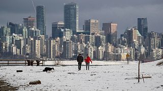 Kutyát sétáltató emberek Vancouverben, British Columbiában 2021. december 25-én