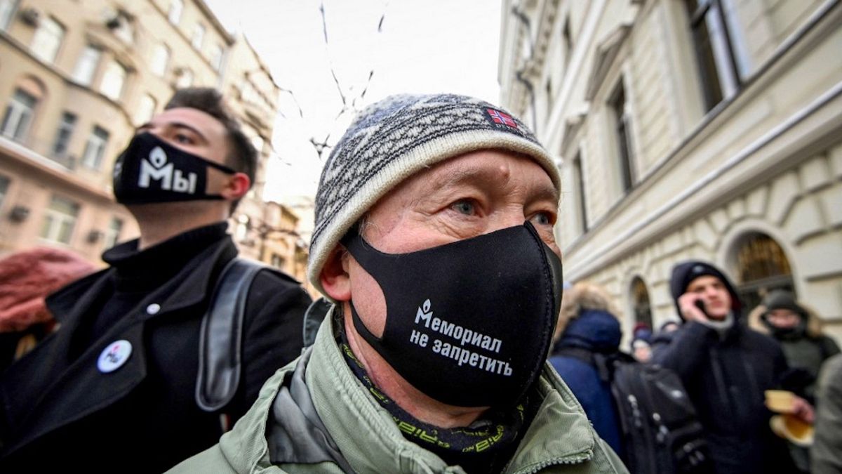 Un soutien de l'ONG avec un masque sur lequel est écrit "Memorial ne peut pas être interdit", devant la cour suprême de Moscou, le 28 décembre 2021
