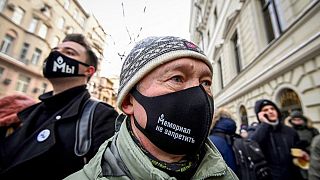 Un soutien de l'ONG avec un masque sur lequel est écrit "Memorial ne peut pas être interdit", devant la cour suprême de Moscou, le 28 décembre 2021