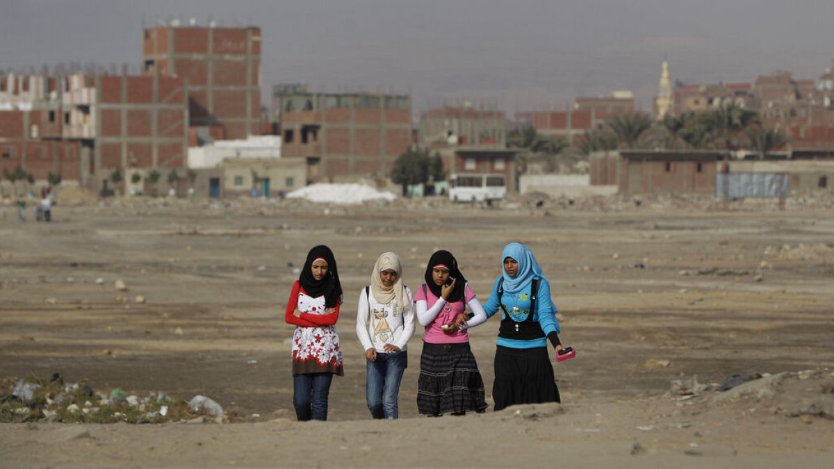فتيات مصريات يمشين عبر أرض نفايات في حي حلوان الذي تقطنه الطبقة العاملة في القاهرة، مصر، الخميس 27 يناير 2011.