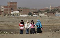 فتيات مصريات يمشين عبر أرض نفايات في حي حلوان الذي تقطنه الطبقة العاملة في القاهرة، مصر، الخميس 27 يناير 2011.