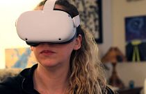Amy Erdt, a community leader in the virtual reality space, sits in her living room and travels to foreign cities virtually using her Oculus headset,