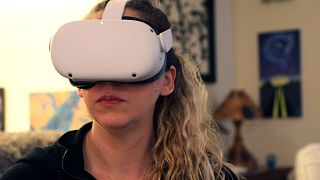 Amy Erdt, a community leader in the virtual reality space, sits in her living room and travels to foreign cities virtually using her Oculus headset,