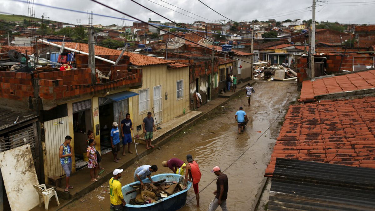 Des habitants nettoient leurs maisons inondées à Itapetinga, dans l'État de Bahia, au Brésil, 28 décembre 2021