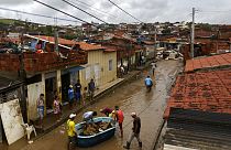 Des habitants nettoient leurs maisons inondées à Itapetinga, dans l'État de Bahia, au Brésil, 28 décembre 2021