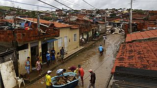 Des habitants nettoient leurs maisons inondées à Itapetinga, dans l'État de Bahia, au Brésil, 28 décembre 2021