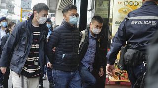 Editor of "Stand News" Patrick Lam, second from left, is arrested by police officers in Hong Kong, Dec. 29, 2021.